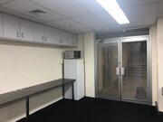 Carpeted office space with fridge and microwave