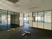 Espace de travail moderne avec de grandes fenêtres et des bureaux privés.